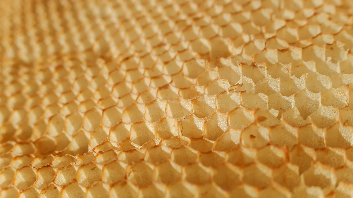 Detailed texture of a honeycomb showcasing hexagonal wax pattern.